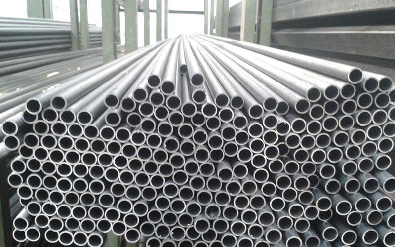 Tubi metallici impilati in un magazzino.