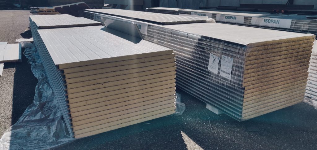 Pannelli isolanti impilati su un piazzale esterno.