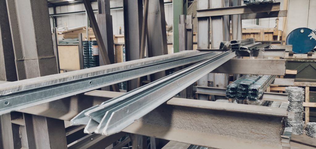 Travi metalliche impilate in un magazzino industriale.